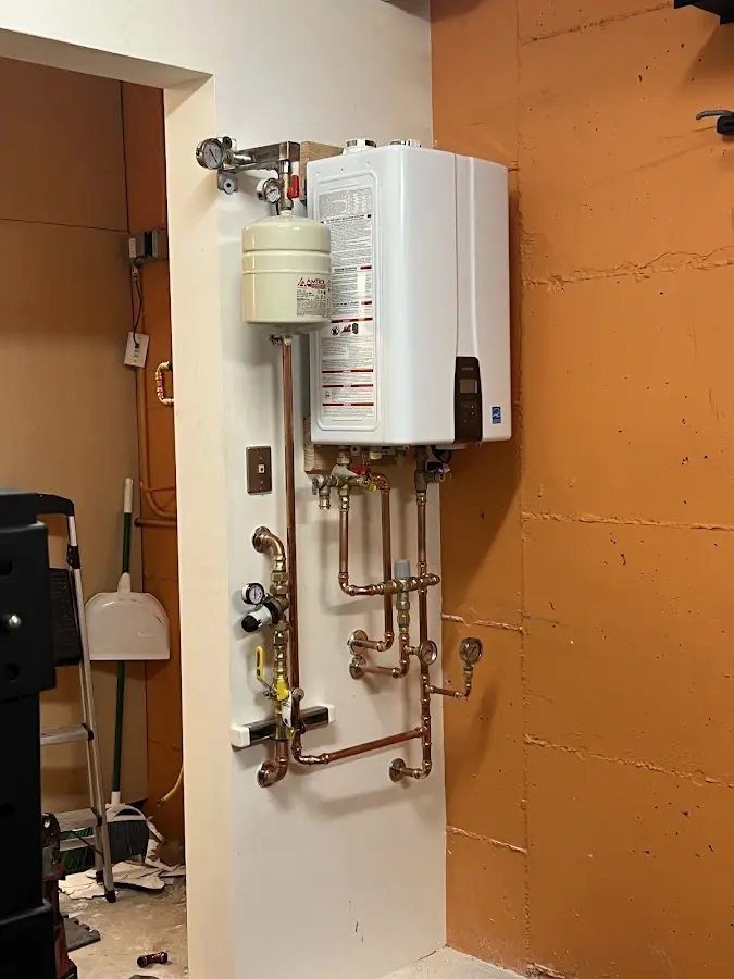 Plumbing technician inspecting water heater connections in Cedar Creek